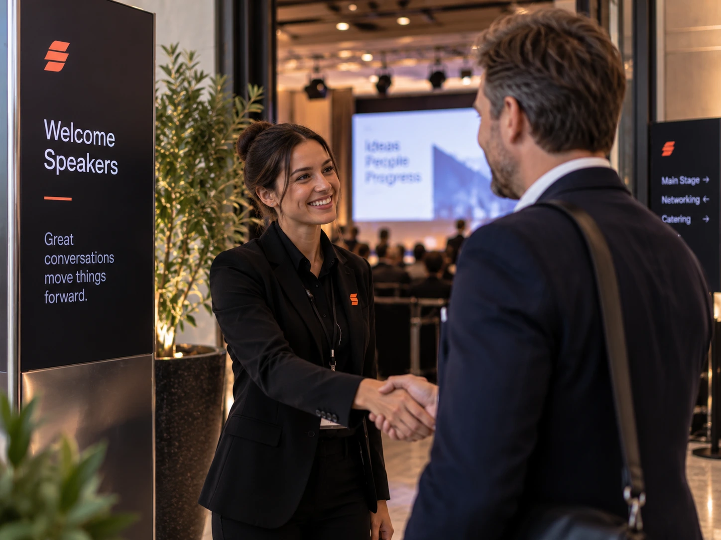 AV-specialist ontvangt een spreker bij de deur van een boardroom.